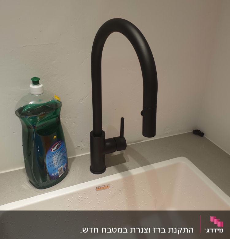 ברז שחור מעל כיור עם סבון כלים ירוק